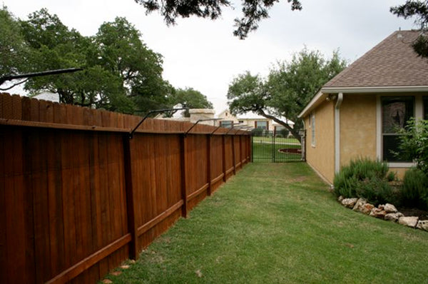 Brown wooden cat fence with purrfect fence extension system