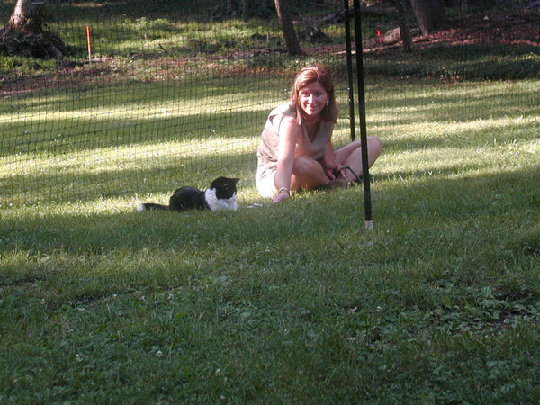 woman playing with a cat in backyard
